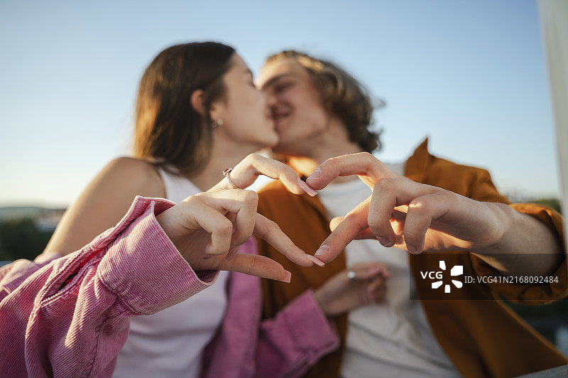 幸福的情侣在阳光明媚的日子，做心形手势图片素材