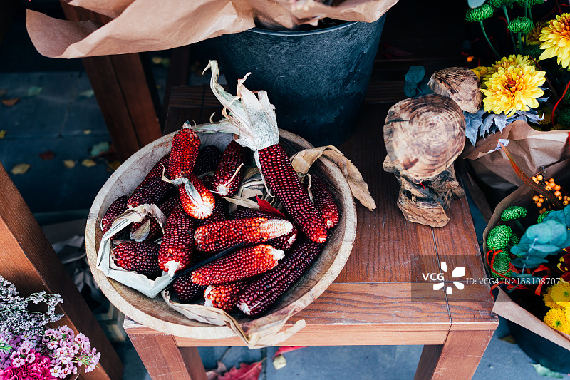 质朴的木碗里盛满了鲜红的玉米，展示了大自然的美丽和秋收图片素材