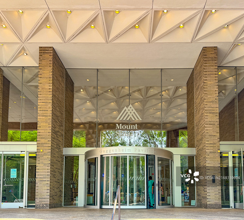 女子进入纽约西奈山医疗中心现代入口的背影图片素材