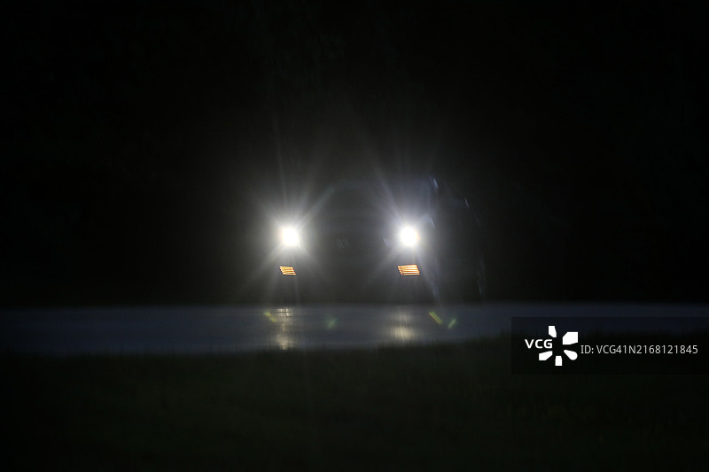 黑暗乡村道路上的车辆大灯图片素材