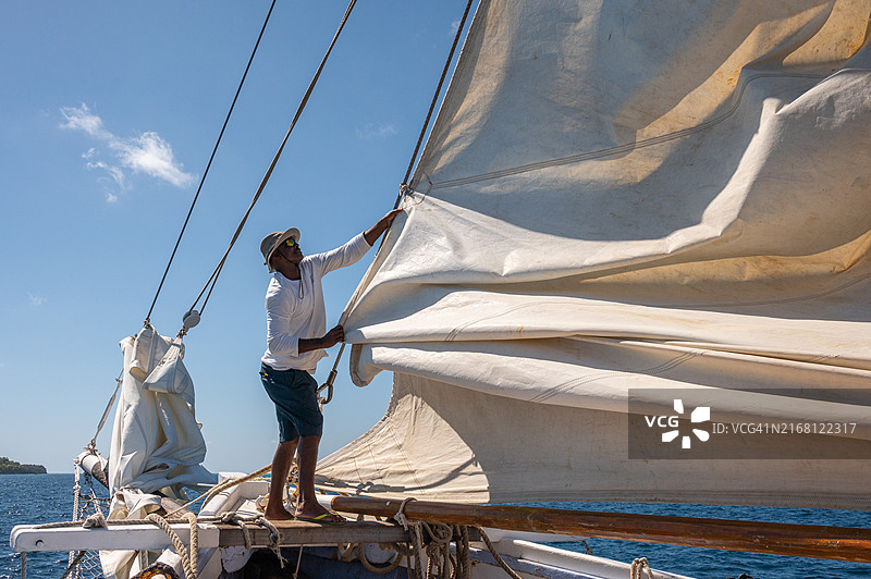 圣文森特和格林纳丁斯，贝基亚岛和多巴哥群岛之间的传统帆船上，船员正在降帆图片素材