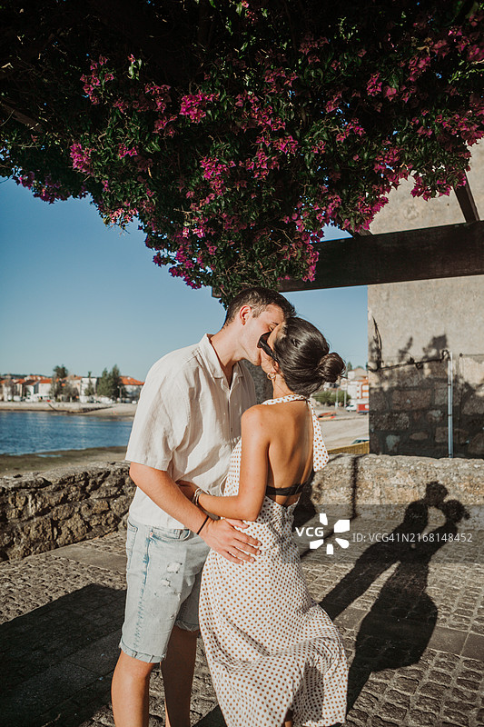 在海边沙丘木板路上散步的年轻夫妇图片素材