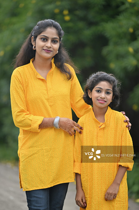 身穿黄色库尔塔的少女和妹妹的肖像图片素材