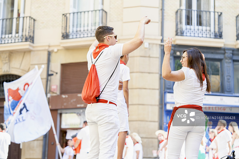 朋友们在潘普洛纳市政厅广场上庆祝圣费尔明节图片素材