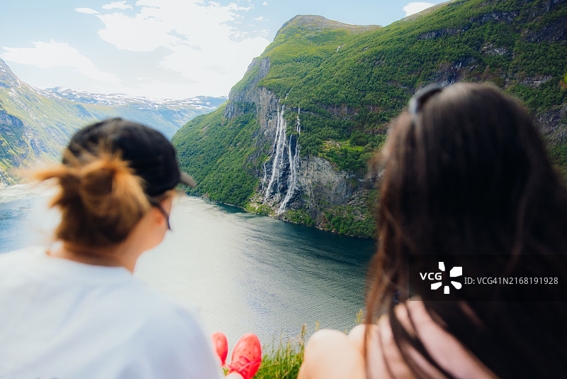 旅行者俯瞰瀑布和盖朗厄尔峡湾的田园风光图片素材