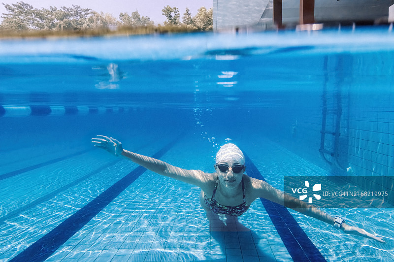 中国女性在水下游泳，微笑看镜头图片素材