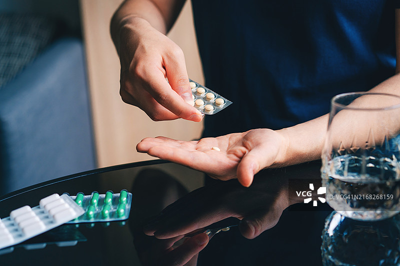 男性手拿药丸泡罩包装的特写，服用药物或维生素图片素材