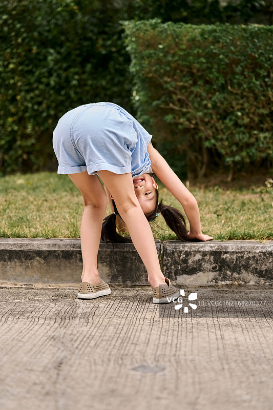 有趣的小女孩弯腰看着相机图片素材