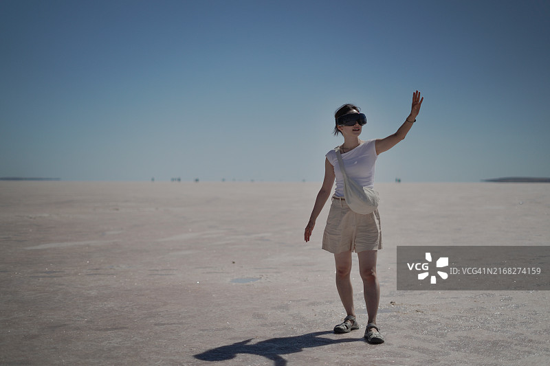 年轻亚洲女性游客在土耳其孔亚盐湖使用VR眼镜图片素材