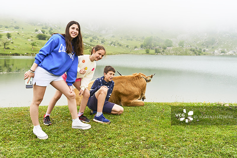 一群穿着休闲装的男子站在科瓦东加湖草坪上微笑看着镜头的正面照图片素材