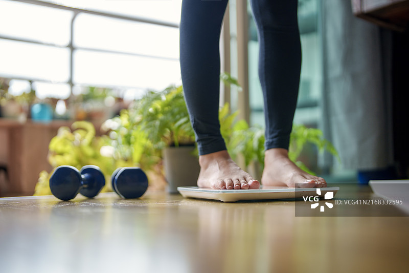 站在体重秤上的年轻女人的特写图片素材