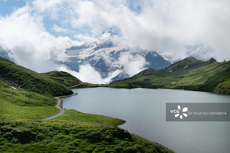 瑞士：绿色的山丘和冰川环绕的田园山地湖泊图片素材