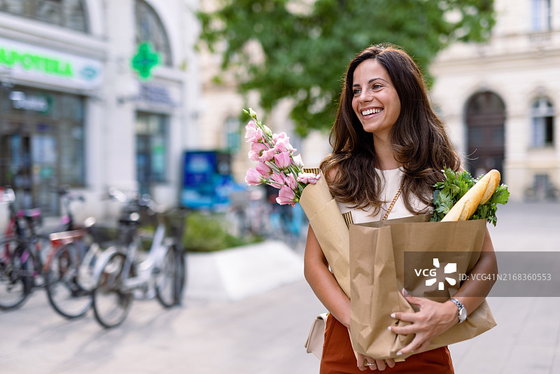 女人在晴朗的一天购买食品和鲜花图片素材