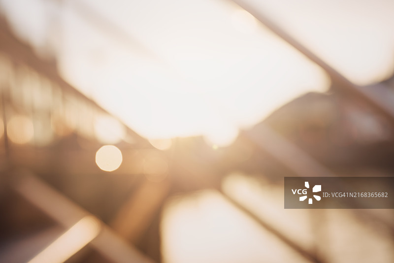 温暖的阳光穿过障碍物，形成柔和的光圈和抽象形状的模糊图像图片素材