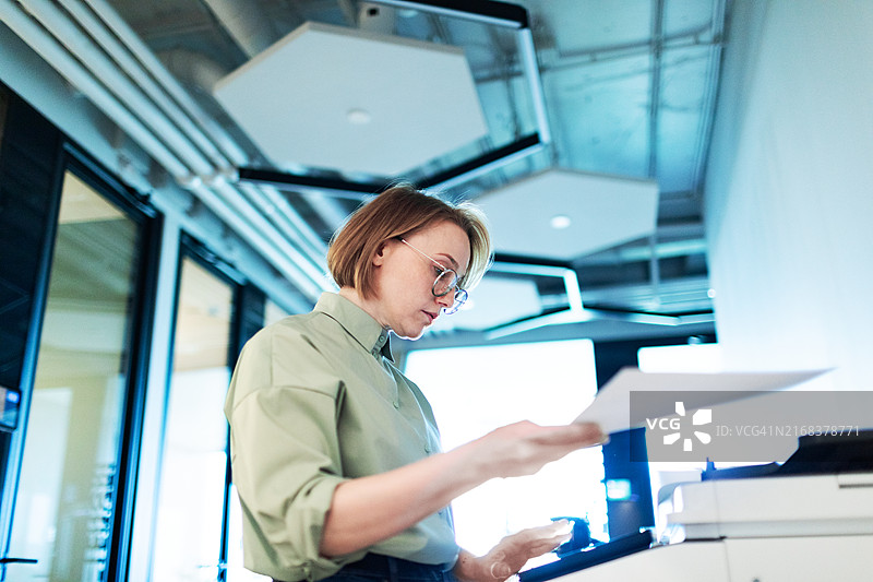 中年妇女在办公室使用扫描仪复印图片素材
