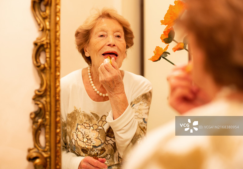 一位90岁高龄的女士在涂口红图片素材