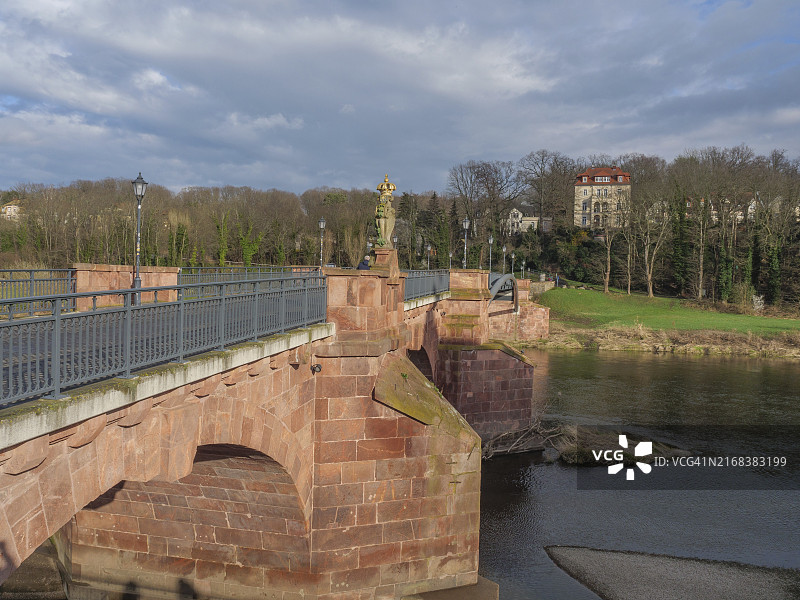 德国德累斯顿：红砖河桥与阴沉的天空、树木背景图片素材