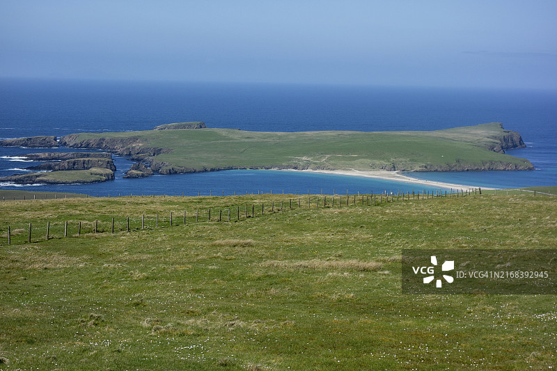 勒威克晴空下平静海域环绕的绿色岛屿图片素材