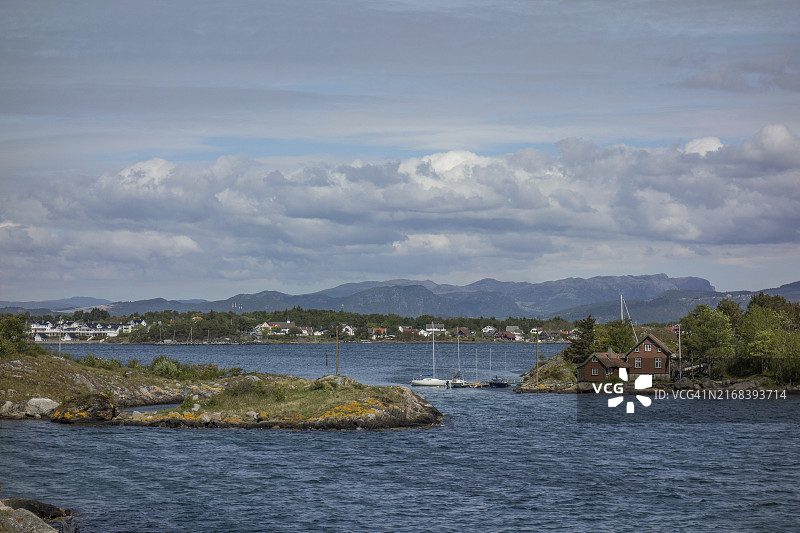 挪威斯塔万格：平静海面上房屋和帆船林立的小岛图片素材