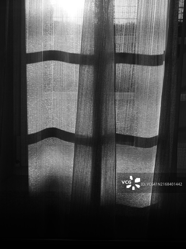 窗帘在窗前的黑白特写，逆光拍摄。日光。葡萄牙，波尔图。图片素材