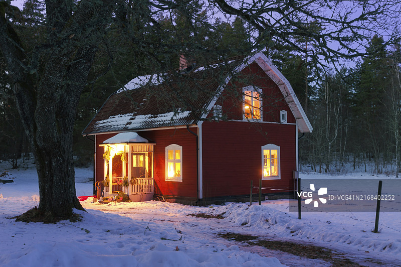 特色瑞典木屋夜景，明亮的窗户，圣诞节，节日气氛图片素材