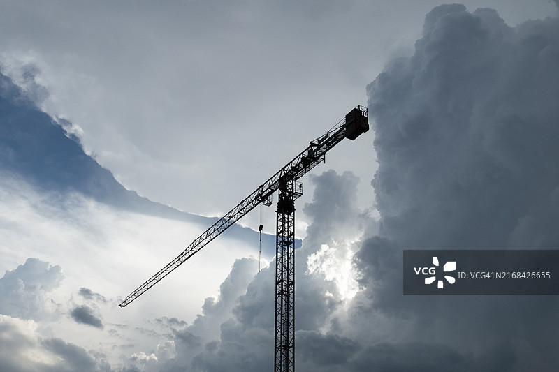 戏剧性天空下的剪影建筑起重机图片素材