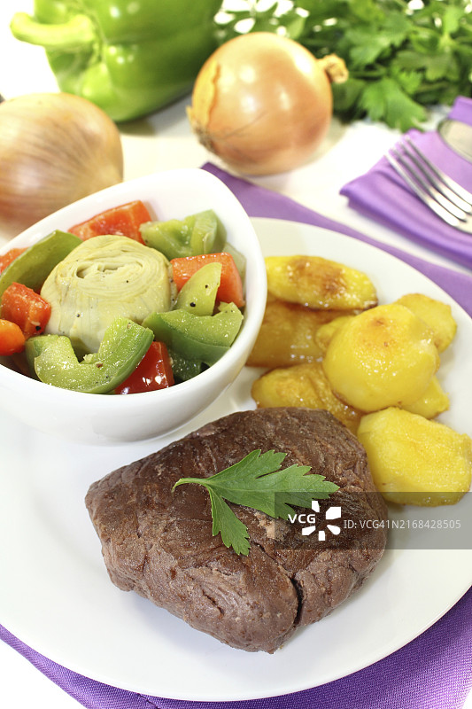 浅色背景上的鸵鸟排和香脆土豆图片素材