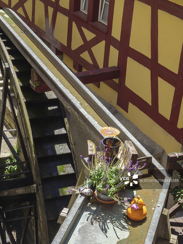 色彩缤纷的鲜花和传统半木结构房屋的美丽水车，德国康斯坦茨湖畔梅尔斯堡图片素材