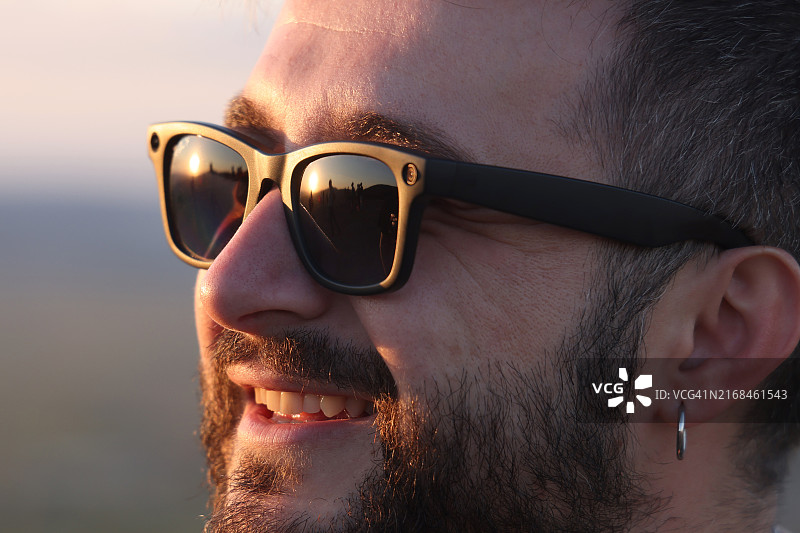 在户外用智能眼镜拍摄视频或照片的微笑男人图片素材