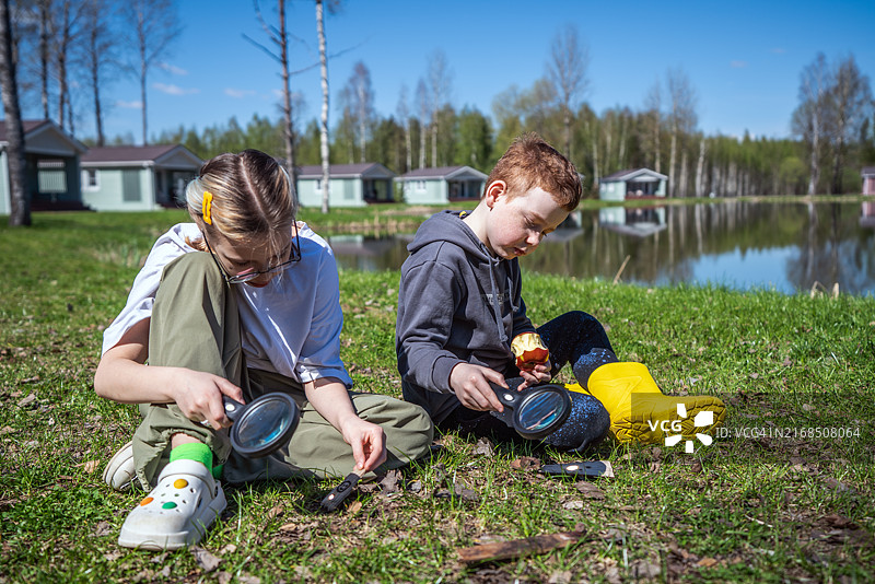 孩子们在露营地玩放大镜图片素材