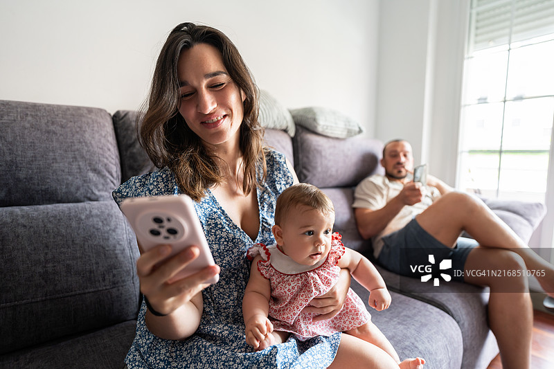 一家人在家共度时光，使用智能手机图片素材