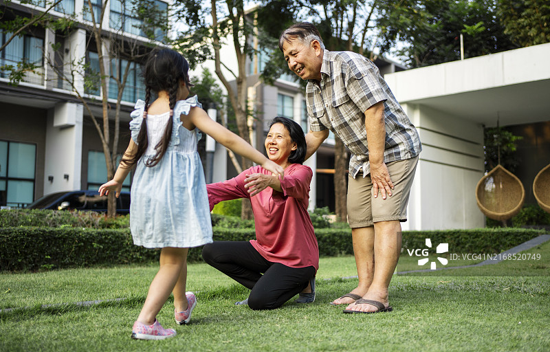 小女孩和祖父母在花园里玩耍图片素材