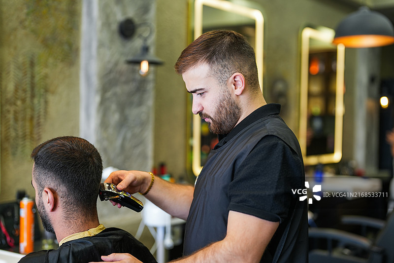 男理发师在美发沙龙理发图片素材