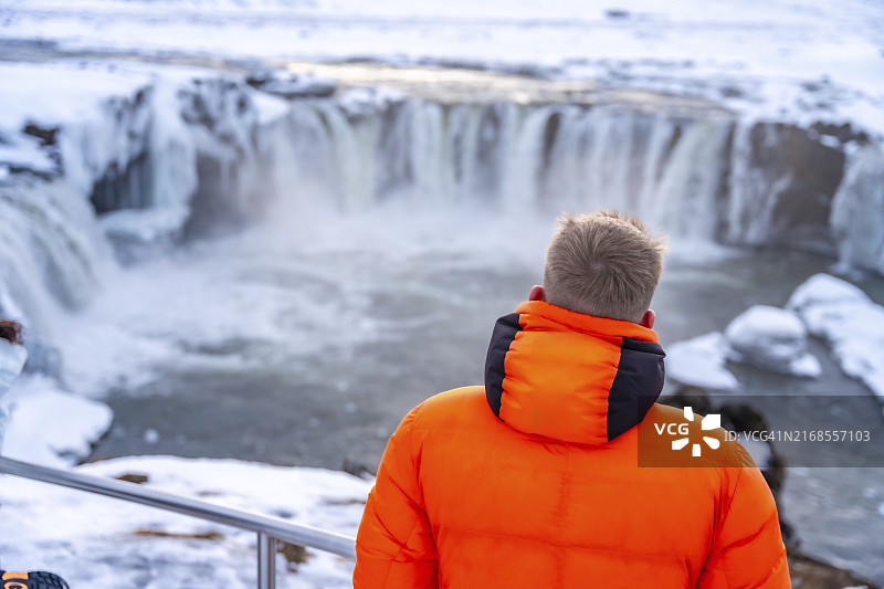 冬季冰岛美丽的众神瀑布，以及正在观赏的男人图片素材