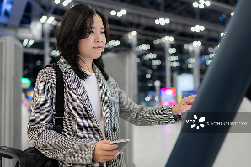 职业女性在机场自助值机亭办理登机牌图片素材