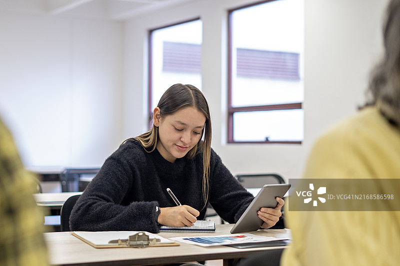 年轻女人在办公室使用平板电脑工作图片素材