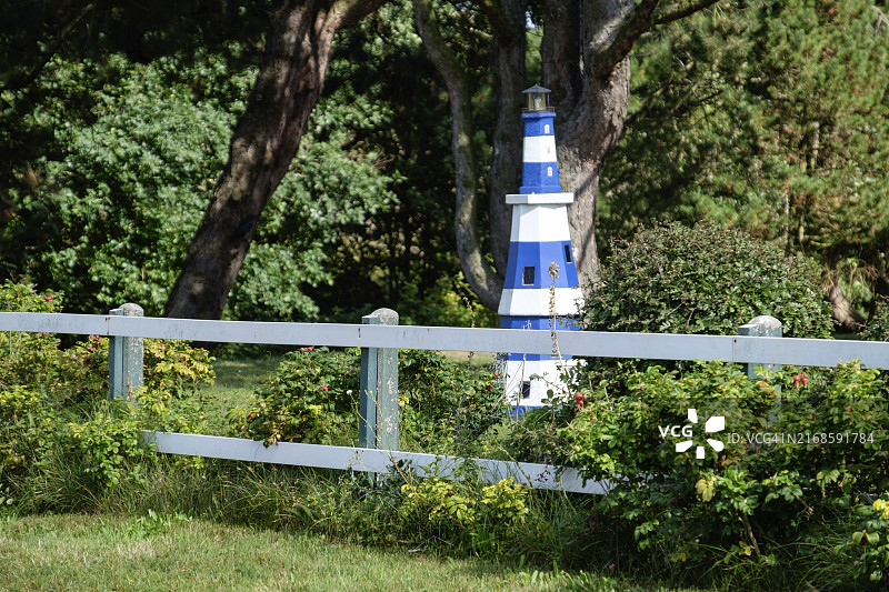 德国北海斯皮克罗格白色栅栏后花园里的小灯塔图片素材