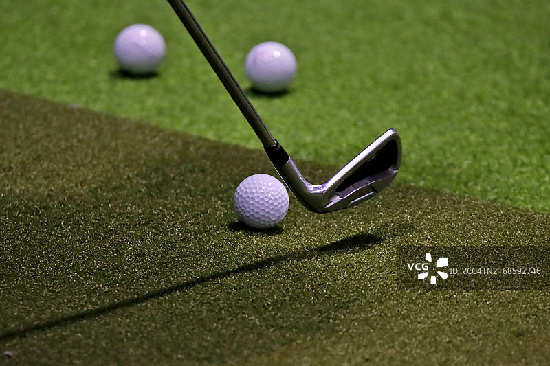 在虚拟高尔夫模拟器中，高尔夫球杆准备击球位置的特写镜头图片素材