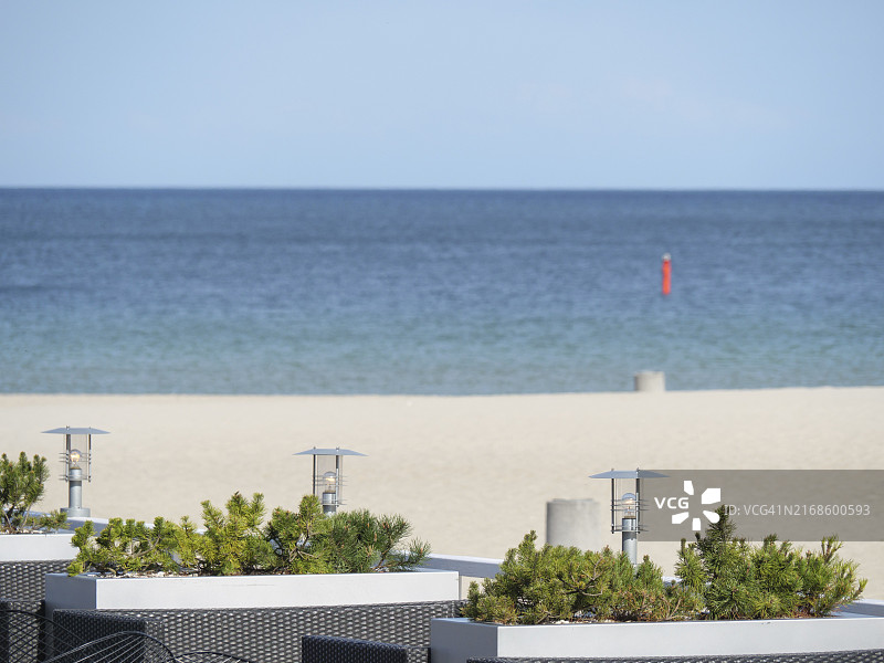 波兰索波特波罗的海：装饰着灯笼和植物的平静蓝色大海和晴朗天空的空旷海滩图片素材