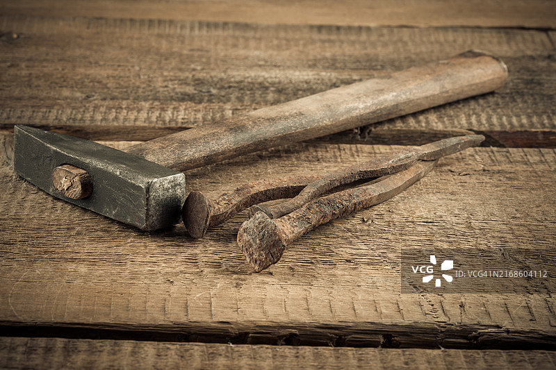 木质背景上的复古铁锤和钉子图片素材