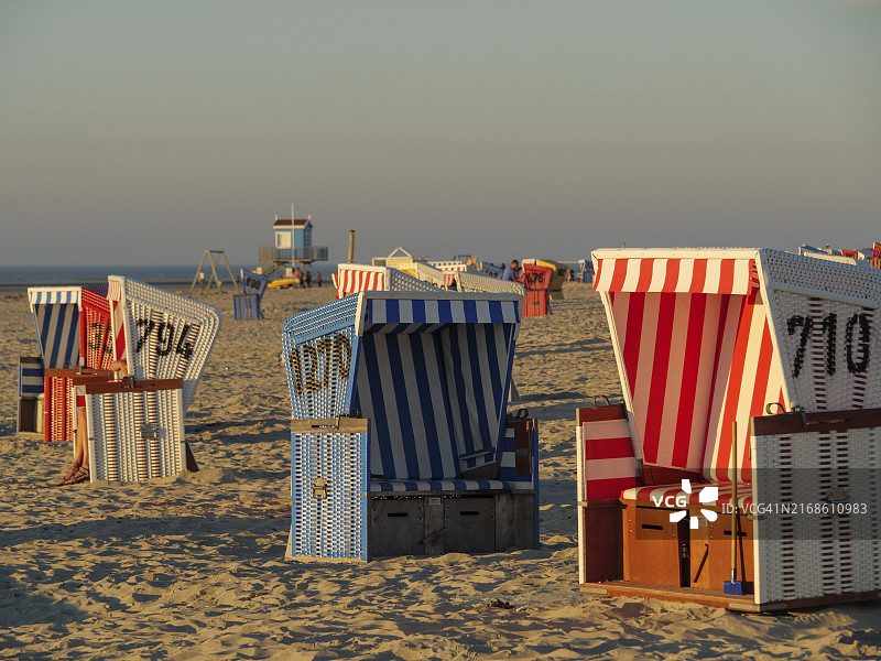沿着海滩排列着不同颜色的沙滩椅，德国东弗里西亚朗格奥格岛图片素材