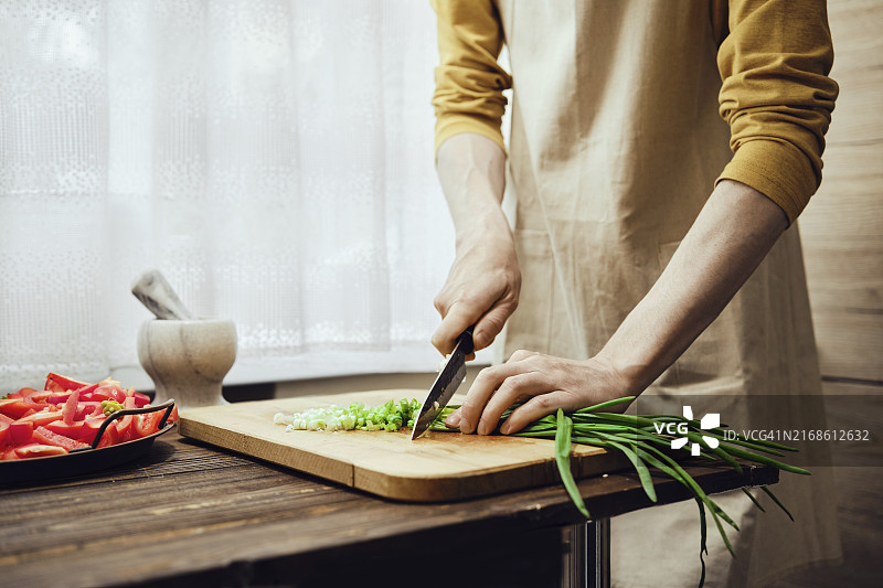 男子在厨房用菜刀切新鲜的葱（未识别面部）图片素材
