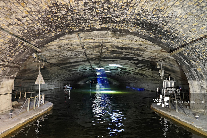 圣马丁运河：巴黎东部的航运运河，黑暗的地铁在水下，被人造光照亮图片素材