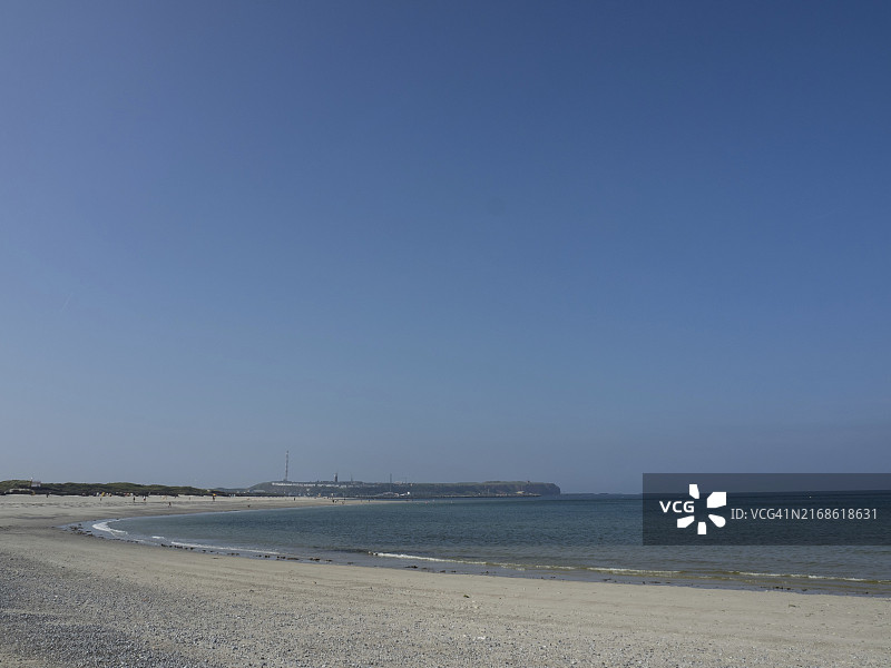 宽敞而安静的海滩，天空晴朗，海面平静，德国北海黑尔戈兰岛图片素材