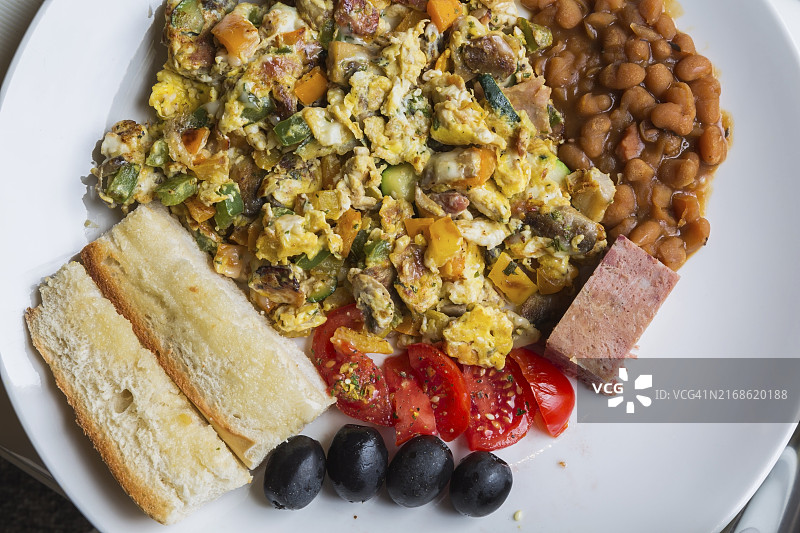 炒鸡蛋早餐配绿色、橙色和黄色甜椒、蘑菇、烤棕豆、红色番茄片、黑橄榄、乡村风味肉酱和法式长棍面包片，魁北克，加拿大，北美图片素材