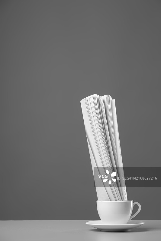灰色背景上的白色马克杯和报纸图片素材