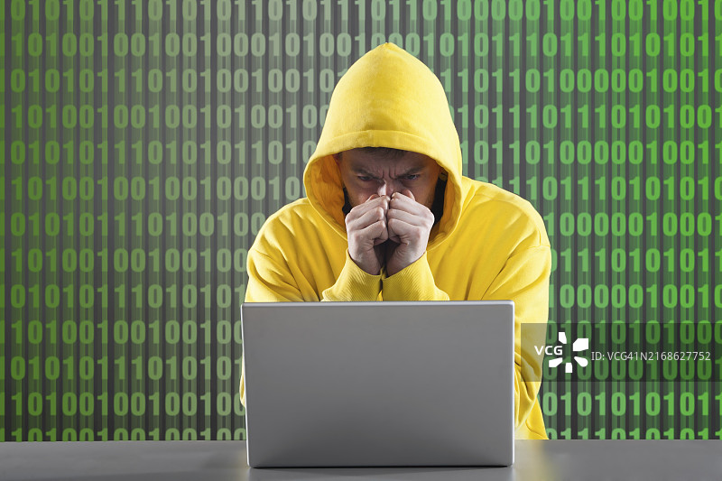 身穿黄色夹克的男子在灰色背景上工作。图片素材