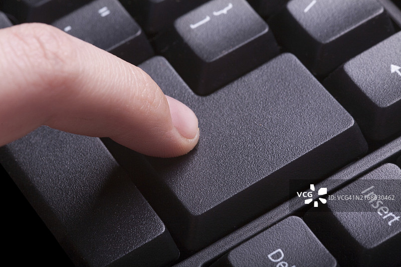 女人使用电脑键盘，按下回车键图片素材