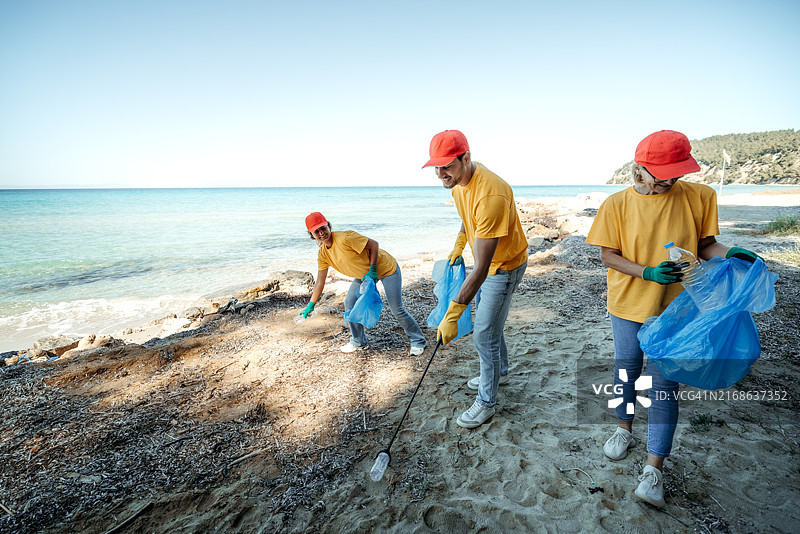 一群志愿者在晴朗的一天一起清理海滩图片素材