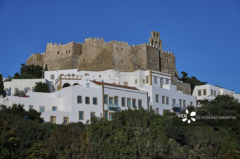 山丘上的城堡，有白色房屋和茂盛的植被，圣约翰修道院，帕特莫斯岛，希腊图片素材